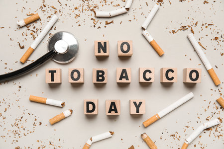 Cubes with text NO TOBACCO DAY, stethoscope and cigarette butts on gray backgroundの写真素材