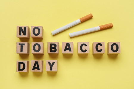 Cubes with text NO TOBACCO DAY and cigarettes on yellow backgroundの写真素材