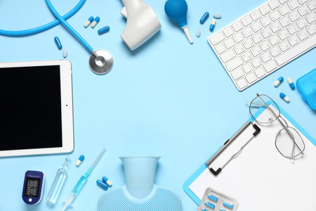 Frame made of blank clipboard, tablet, keyboard and medical supplies on blue background. World Health Dayの写真素材