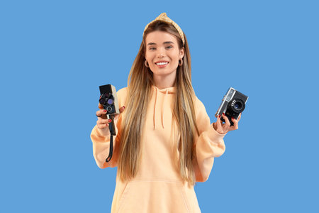 Stylish young woman in hoodie on blue background