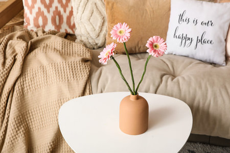 Vase with beautiful flowers on coffee table in stylish living room, closeupの写真素材