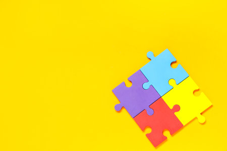 Colorful puzzle pieces on yellow background. Autistic disorder conceptの写真素材