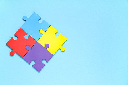 Colorful puzzle pieces on blue background. Autistic disorder concept