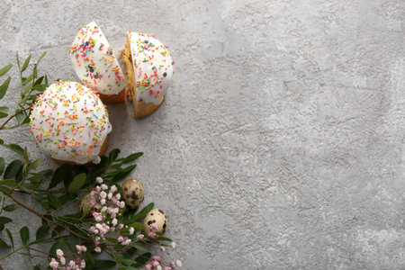 Sweet Easter cakes with quail eggs and gypsophila flowers on gray background