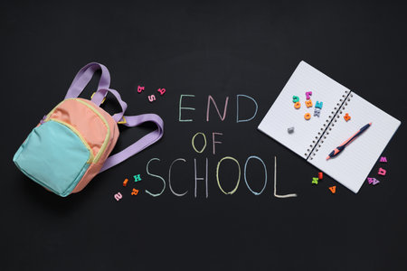 Chalkboard with text END OF SCHOOL, backpack and notebookの写真素材