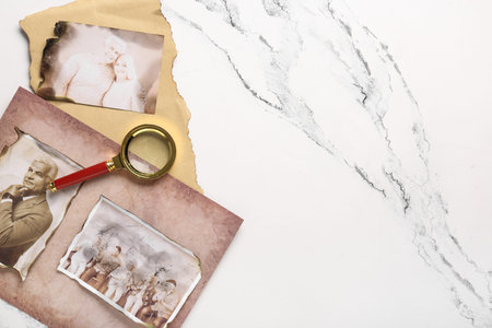 Old photos of relatives with magnifier on white background with space for text. Concept of family...