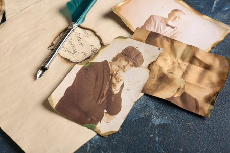 Old photos of relatives with pen on dark blue background. Concept of family treeの写真素材