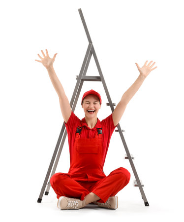 Happy female worker with stepladder sitting on white backgroundの写真素材