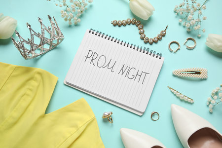 Notebook with text PROM NIGHT, festive outfit, jewelery and flowers on turquoise backgroundの写真素材