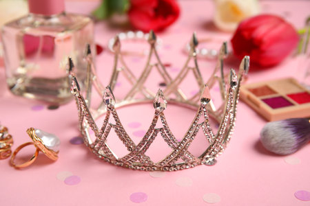 Tiara with makeup products, perfume and tulip flowers on pink background. Prom conceptの写真素材