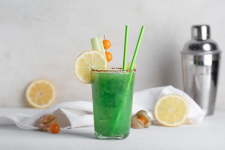 Glass of green bloody mary cocktail garnished with physalis berries and lemon on white backgroundの写真素材