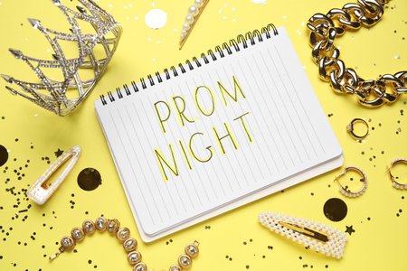 Notebook with text PROM NIGHT, tiara, jewelery and confetti on yellow backgroundの写真素材