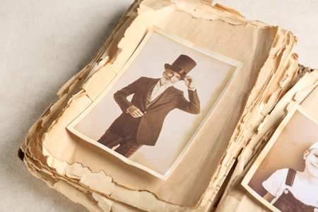 Old album with photos of relatives on light background. Concept of family treeの写真素材