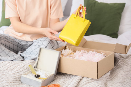 Young fashion blogger unpacking new stylish bag and wrist watch at home, closeup