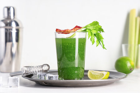 Glass of green bloody mary cocktail with bacon, celery and lime on white backgroundの写真素材