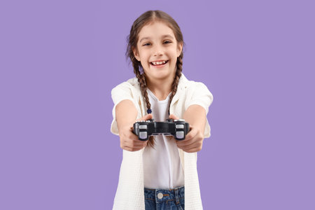 Cute girl with game pad on lilac backgroundの写真素材