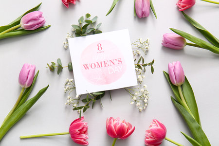 Greeting card with gypsophila flowers and beautiful tulips on gray background. International Women's...