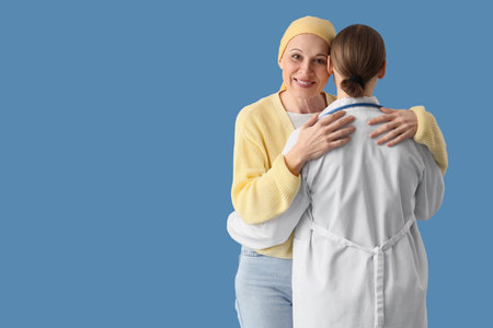 Mature woman after chemotherapy hugging doctor on blue background. Brain cancer conceptの写真素材