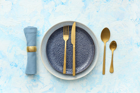 Beautiful table setting on blue grunge background. Top view