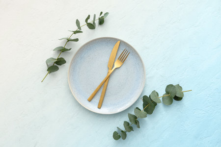Stylish table setting with eucalyptus branches on blue grunge background. Top viewの写真素材