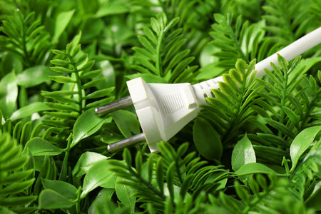 Electrical plug and green leaves. Concept of green technologyの写真素材