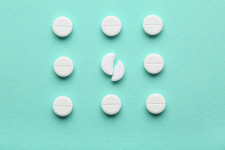 Many white pills on turquoise background