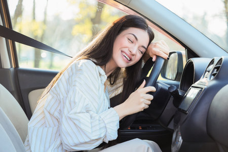 Happy young woman sitting in car
