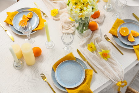 Beautiful table setting with daffodils and oranges, top viewの写真素材
