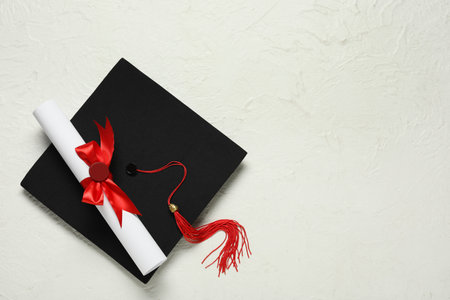 Graduation hat and diploma on white background, top viewの写真素材