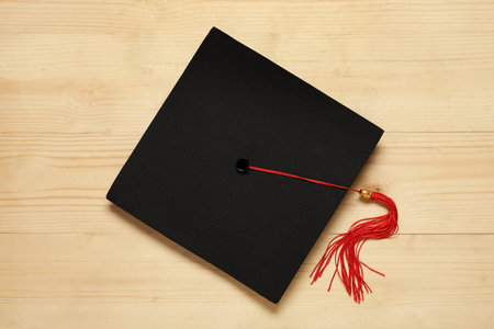 Graduation hat on wooden background, top viewの写真素材
