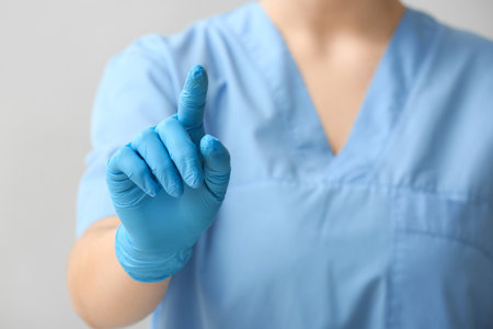 Female doctor using virtual screen on light background, closeupの写真素材