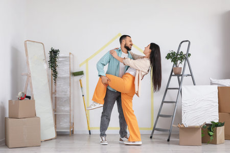 Happy young couple dancing in room on moving day