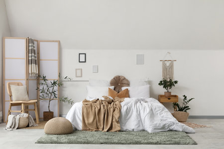 Interior of light bedroom with folding screen, chair and plantsの写真素材