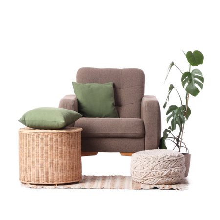 Armchair with basket, pouf and palm plant on white backgroundの写真素材