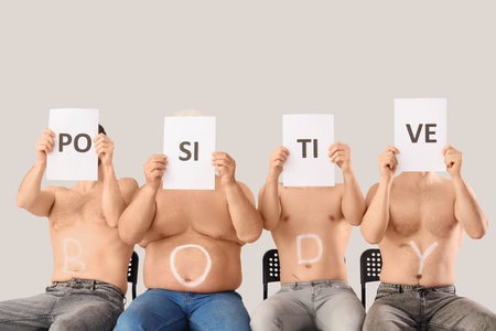 Group of men with text BODY POSITIVE on gray backgroundの写真素材