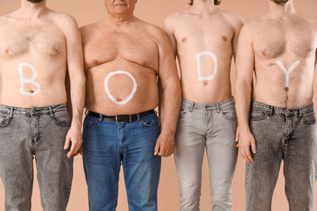 Group of men with the word BODY on their skin against beige background. Body positive conceptの写真素材