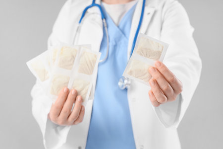 Female doctor with mustard plasters on gray background, closeupの写真素材