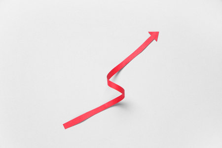 Red paper arrow on light backgroundの写真素材