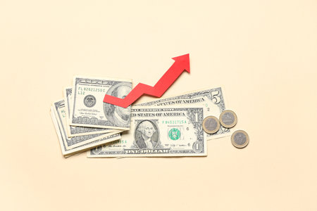 Money and arrow on beige background. Concept of rising priceの写真素材