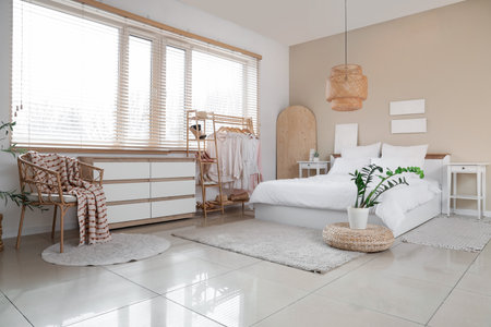 Interior of studio apartment with bed, armchair and clothes rackの写真素材