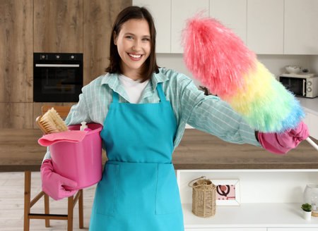 Female janitor with cleaning supplies in kitchen