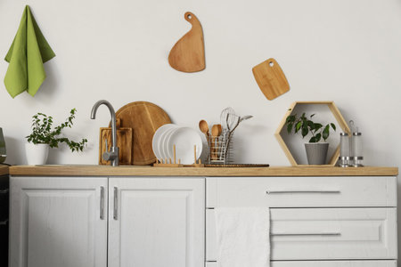 Wooden counter with sink, plates and different kitchen utensilsの写真素材