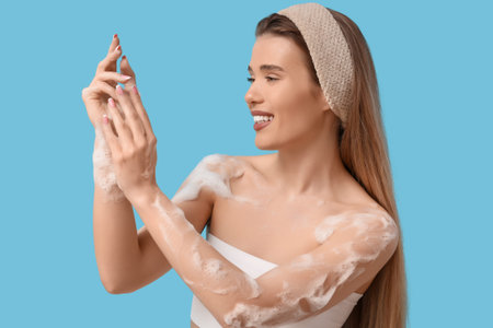 Pretty young woman in headband with foam on blue background