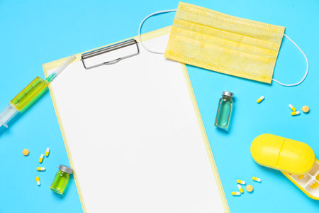 Blank clipboard with pills and medical supplies on blue background. World Health Dayの写真素材