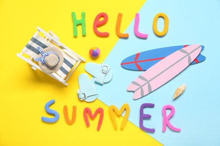 Composition with text HELLO SUMMER and mini beach accessories on color backgroundの写真素材