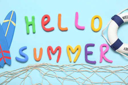 Composition with text HELLO SUMMER, fish net, mini surfboards and lifebuoy on color backgroundの写真素材