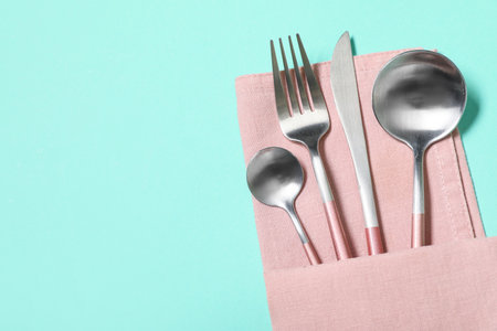 Stylish silver cutlery on turquoise backgroundの写真素材