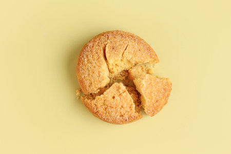 Broken sweet cookie on yellow backgroundの写真素材