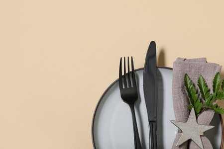 Beautiful table setting with black cutlery and fresh leaf on yellow backgroundの写真素材