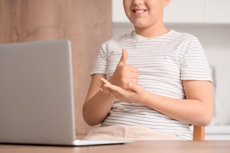 Boy using sign language during video call at homeの写真素材